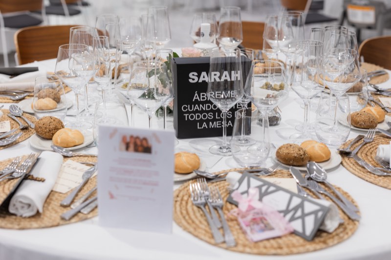 Detalle de la mesa de invitados con tarjeta personalizada y pan artesanal
