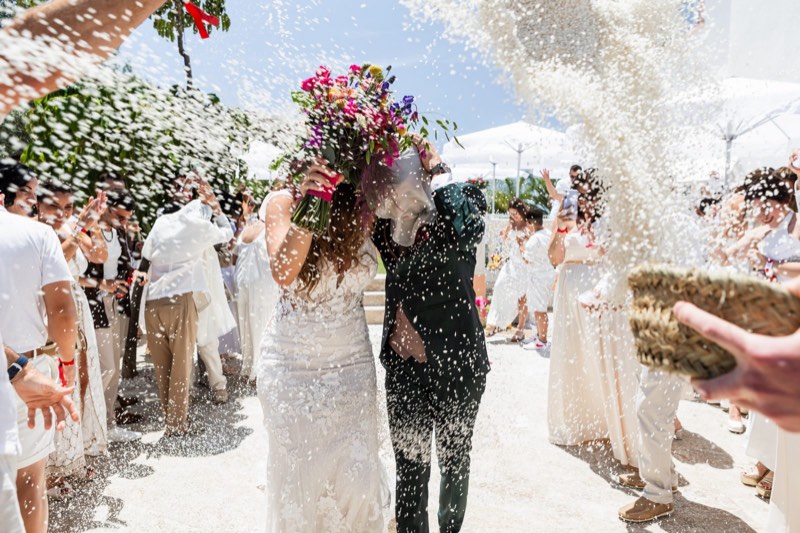 Los novios saliendo de la ceremonia entre lluvia de arroz