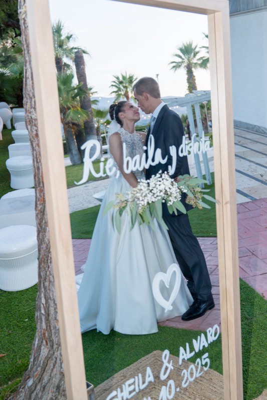 Los novios posando en el photocall con espejo